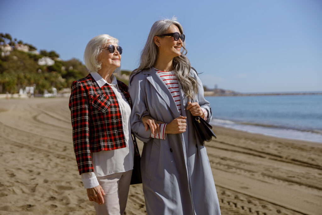 Cheerful mature ladies relaxing outdoors at coastline